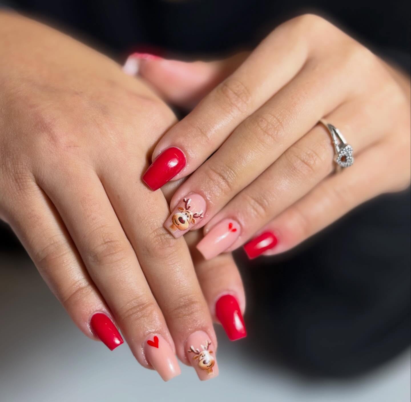 Red gel nails with reindeer nail art